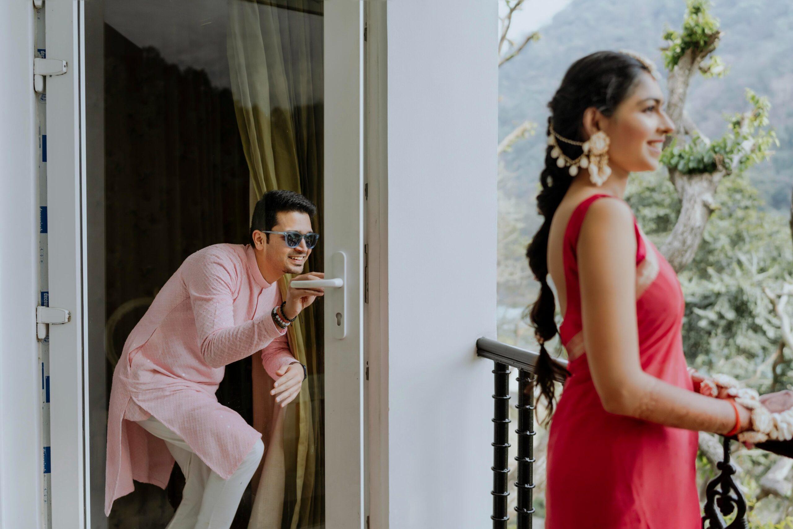 bride and groom getting fun standing on a balcony before marriage