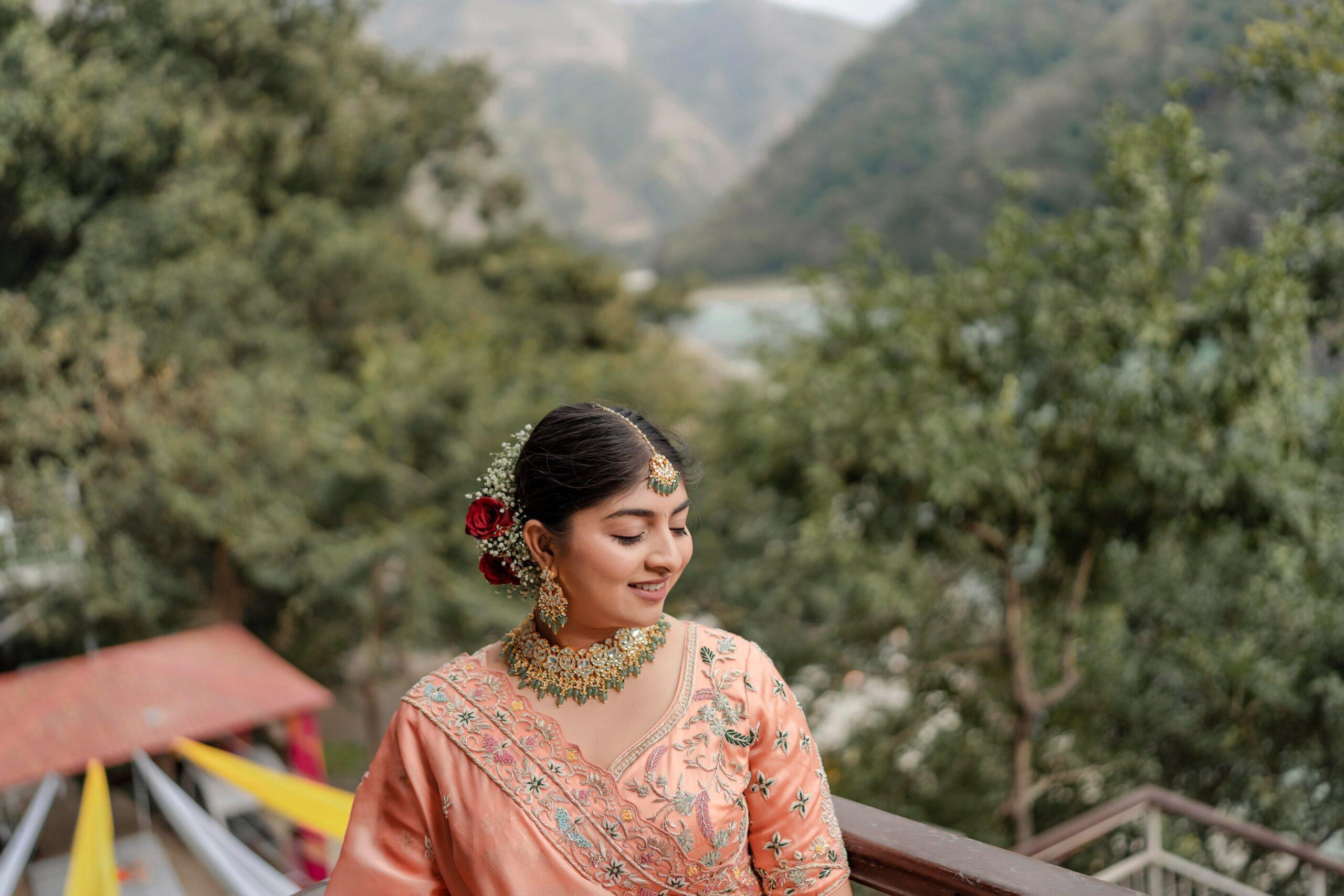 a woman in a peach colored wedding sari at her wedding day